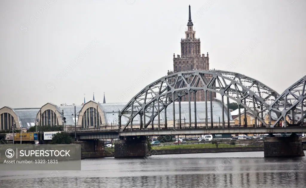 Latvia, Riga, View of train bridge over Daugava River, with Stalin Tower and Central Market