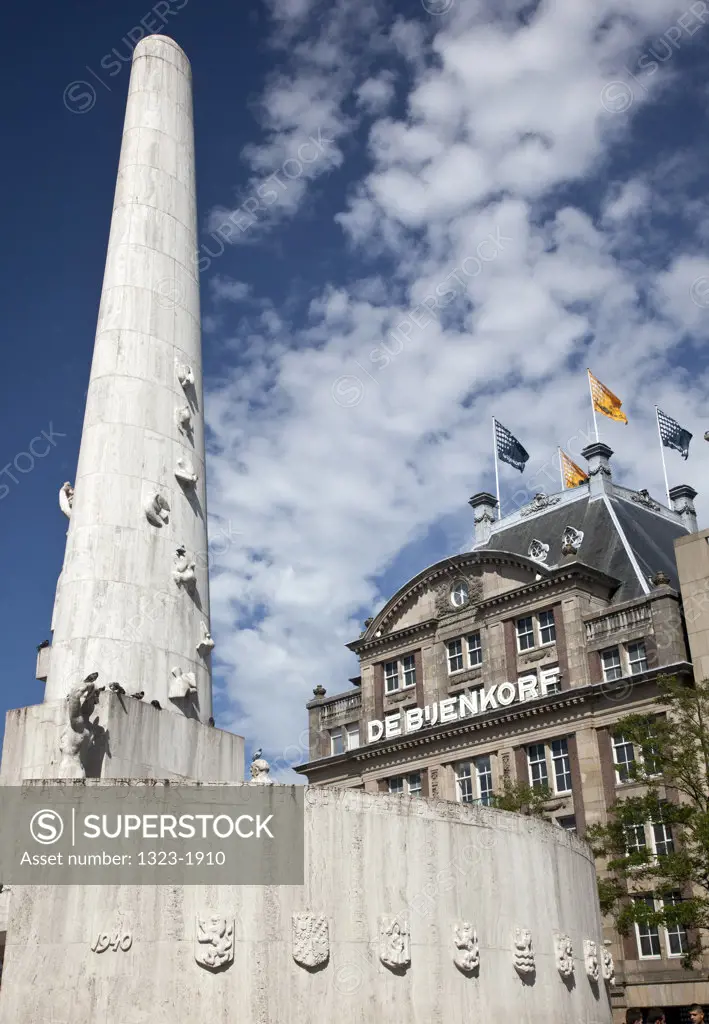 Low angle view of National Monument and De Bijenkorf in Dam Square, Amsterdam, Netherlands