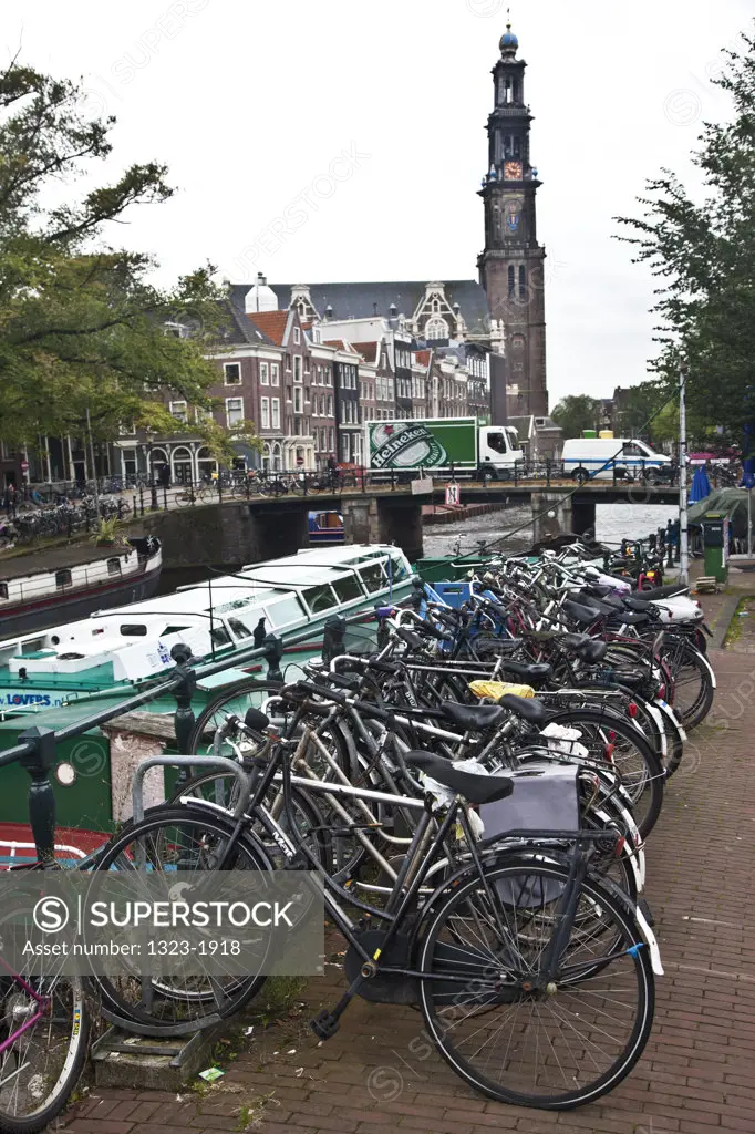 Bicycles along a canal with a church in the background, Westerkerk, Amsterdam, Netherlands