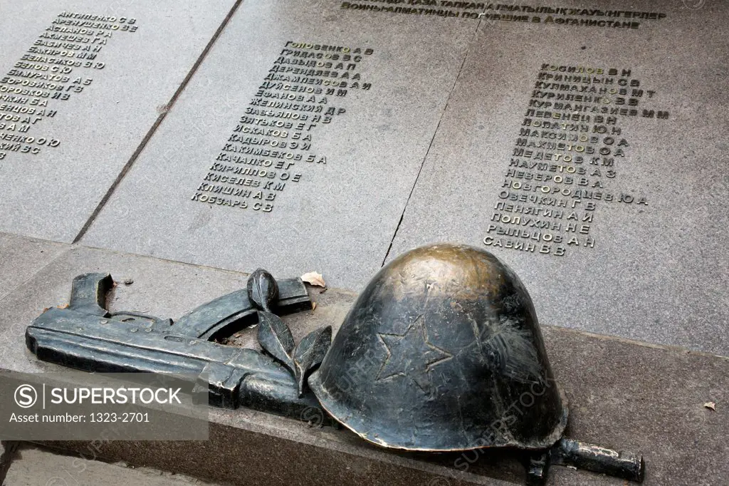 Helmet and machine gun on a memorial plaque at a War memorial in Panfilov Park, Almaty, Kazakhstan