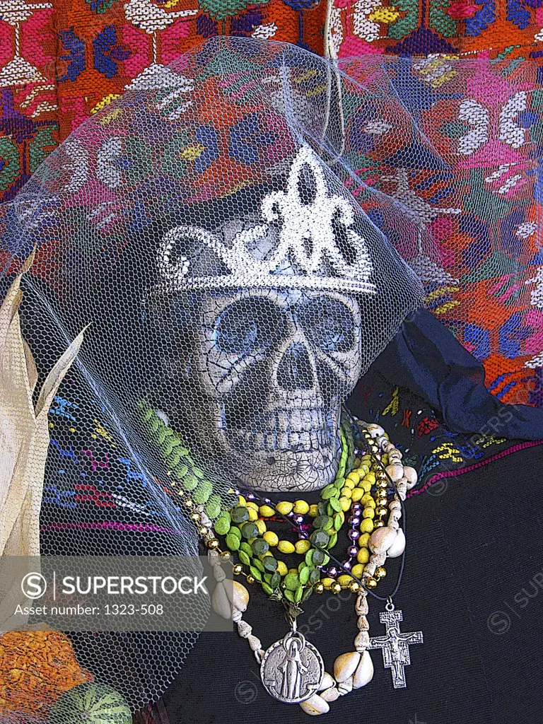 Close-up of a skull wearing necklaces and a tiara