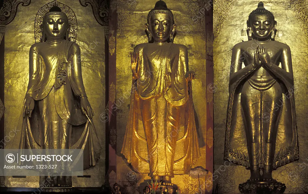 Close-up of three statues of Buddha