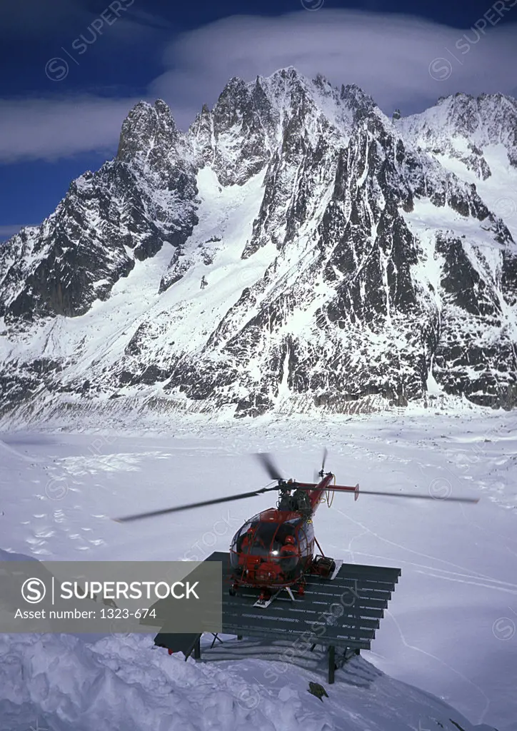 Helicopter on a landing pad in front of a mountain, La Mer de Glace, Vallee Blanche, Chamonix, France