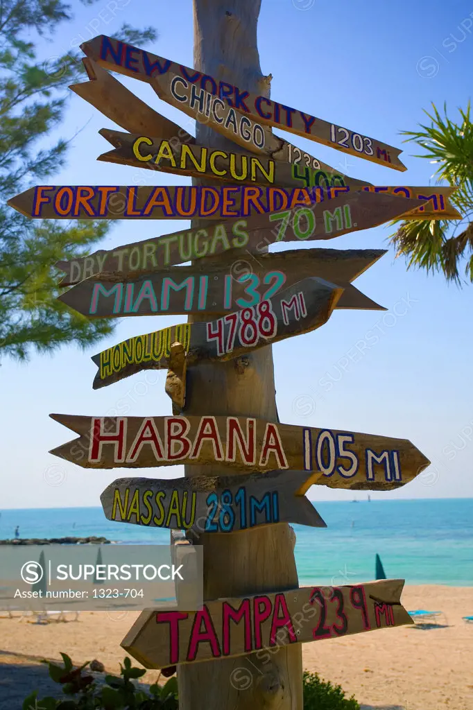 Directional signs on a wooden post on the beach, Key West, Florida, USA
