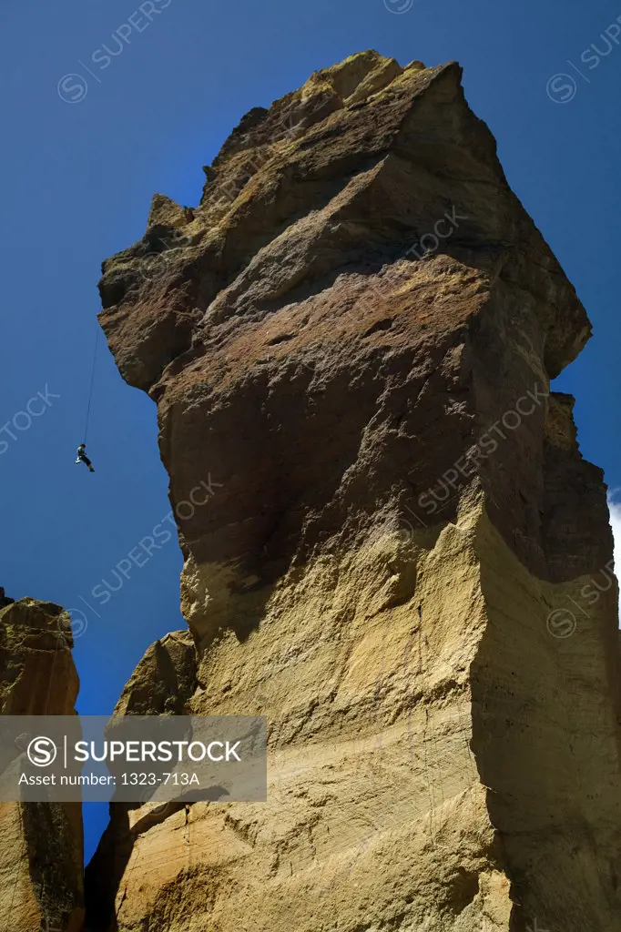 Low angle view of a person rappelling down from a rock, Monkey Face, Smith Rock State Park, Oregon, USA