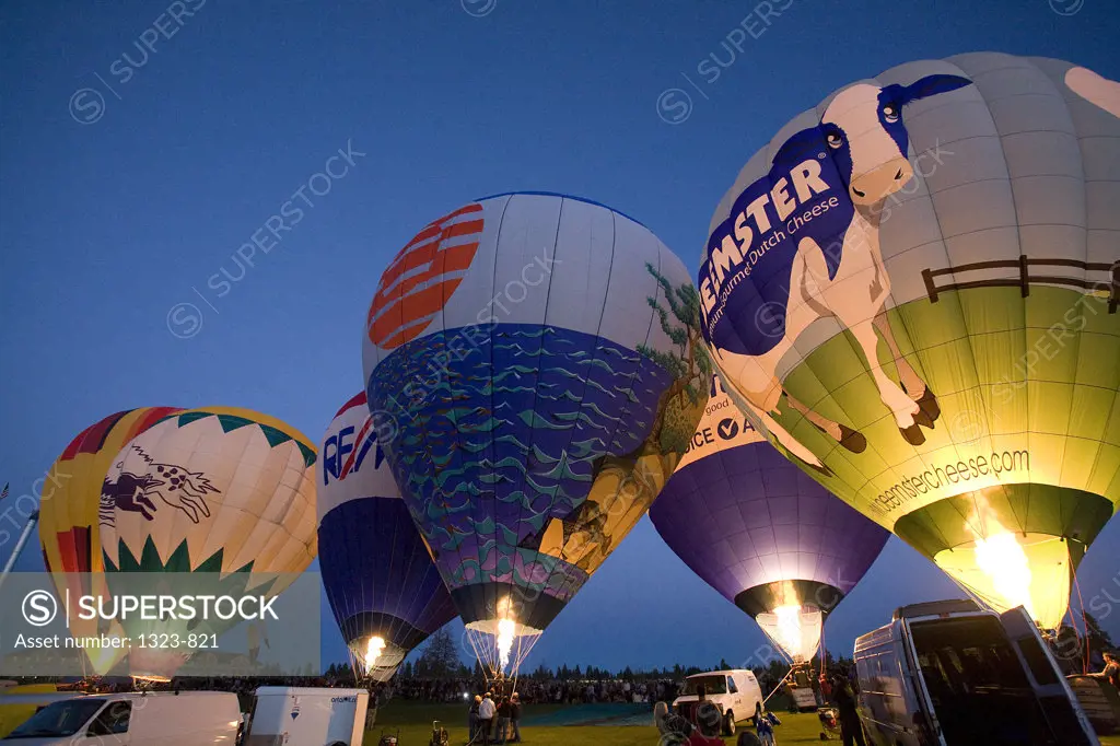 Low angle view of hot air balloons being inflated with a propane heater, Bend, Oregon, USA