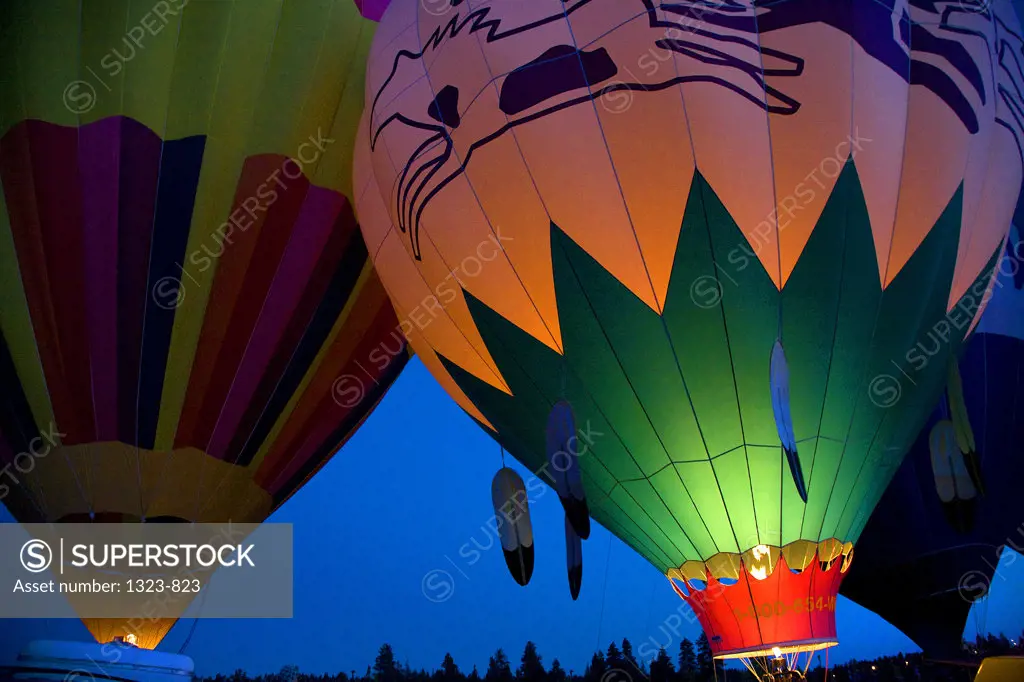 Low angle view of hot air balloons being inflated with a propane heater, Bend, Oregon, USA