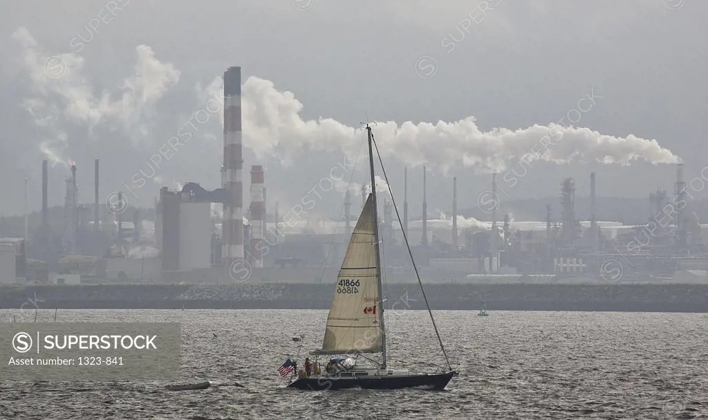 Sailboat in a bay with an oil refinery in the background, Bay Of Fundy, St. John, New Brunswick, Canada