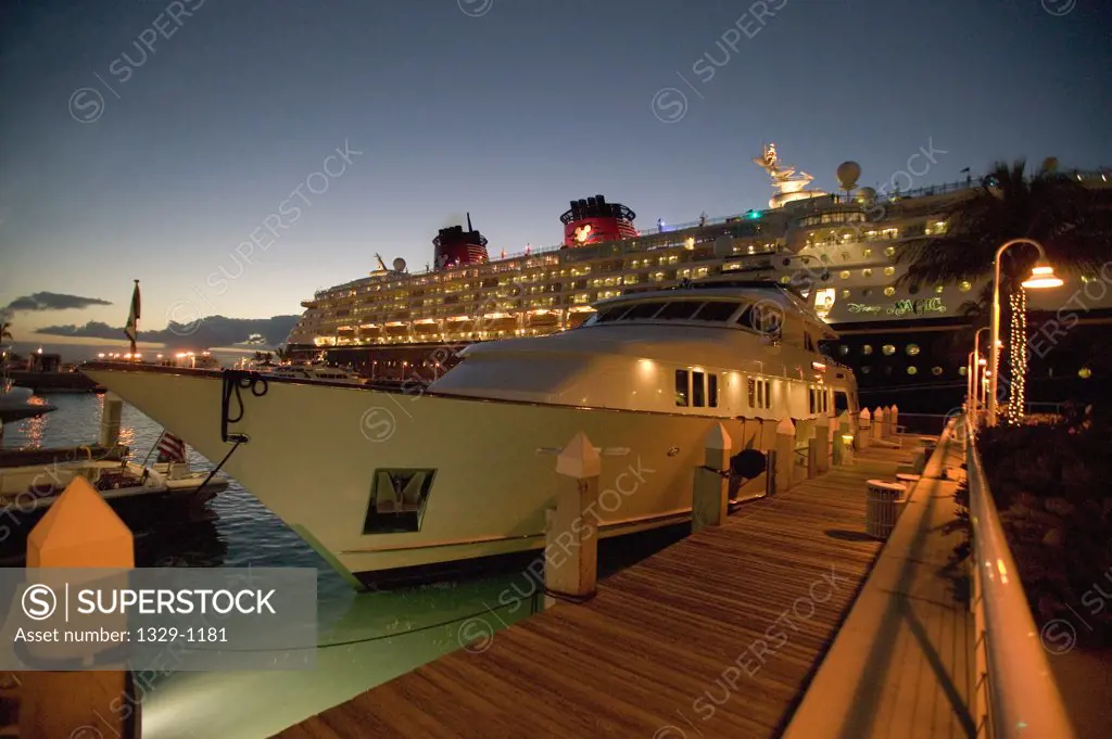Docked yacht at sunset with Disney cruise ship in background, Florida, USA