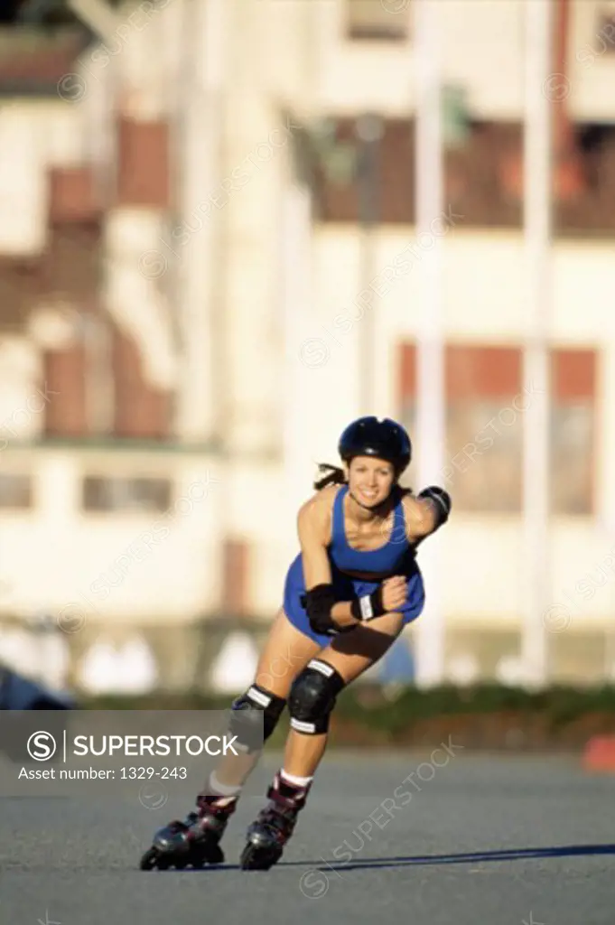 Portrait of a young woman inline skating on a road