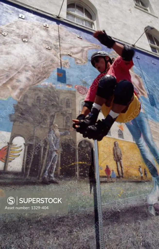 Low angle view of a young man performing stunts with inline skates