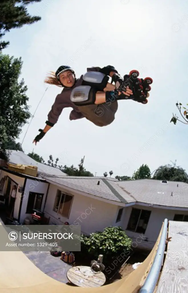 Low angle view of a young woman performing stunts with inline skates