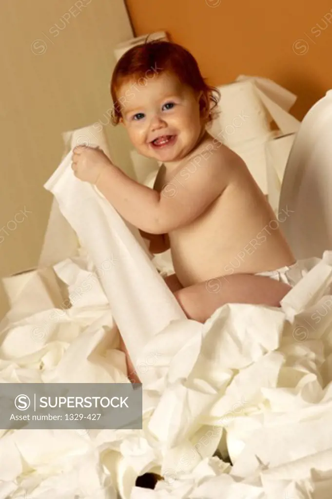 Portrait of a baby boy holding toilet paper