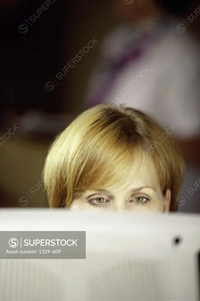 Close-up of a businesswoman in front of a computer monitor