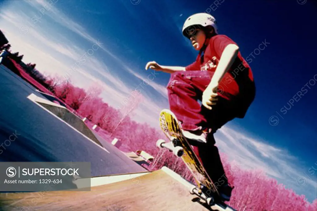 Low angle view of a boy skateboarding on a ramp