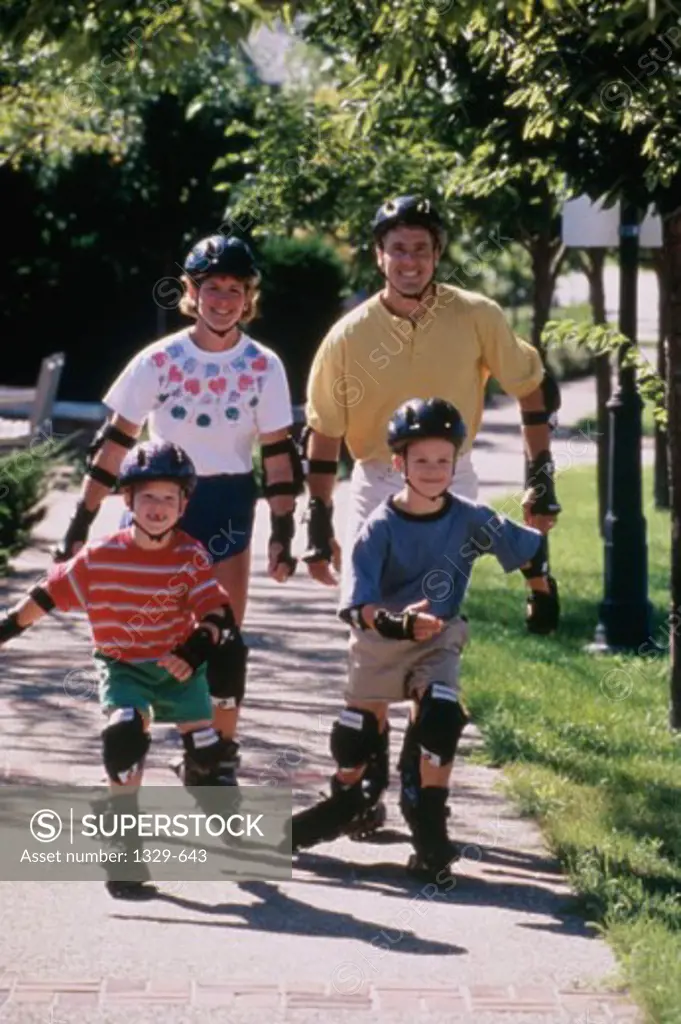 Parents with their two sons inline skating on a walkway