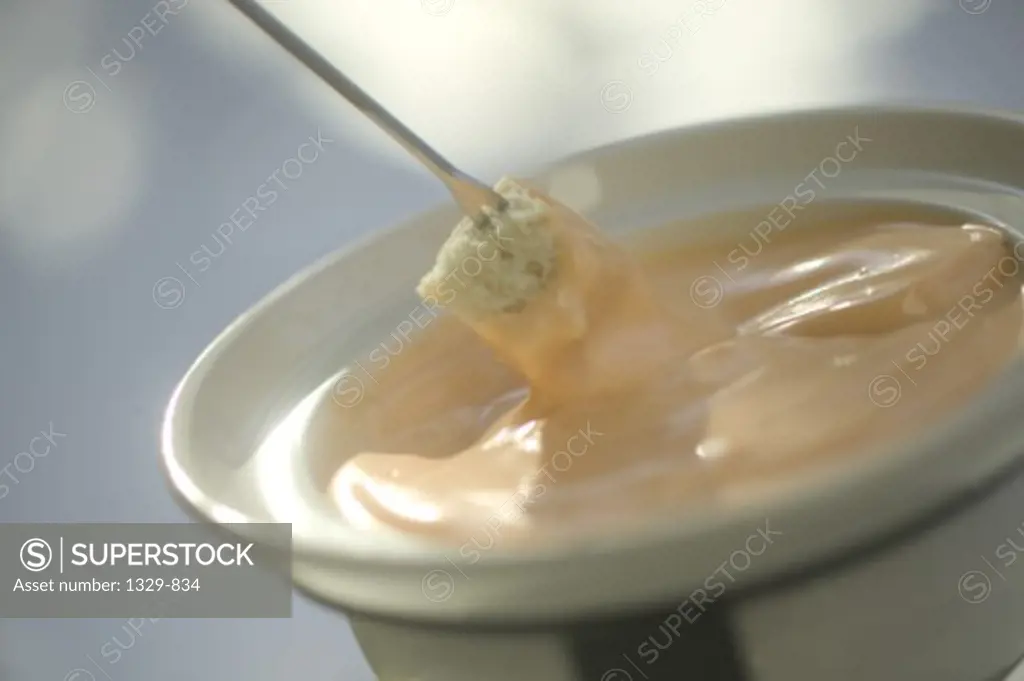 Close-up of a fondue of melted cheese in a bowl