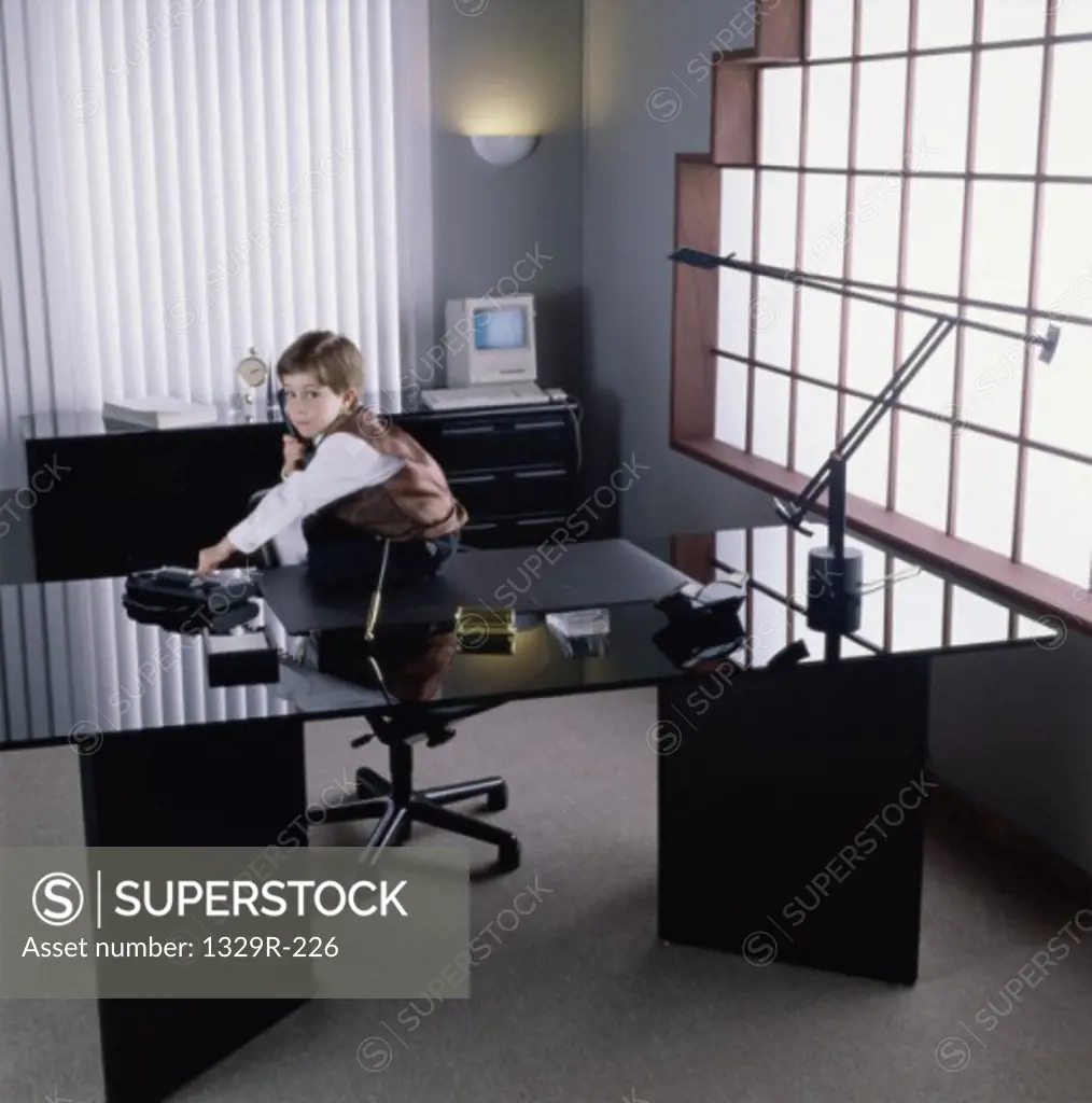 Portrait of a young girl dressed as a businesswoman sitting in an office
