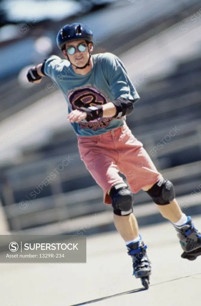 Portrait of a young man inline skating on road