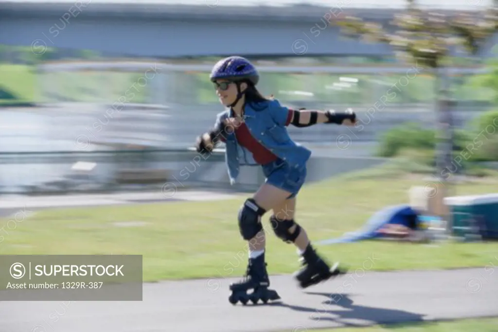 Teenage girl inline skating on road