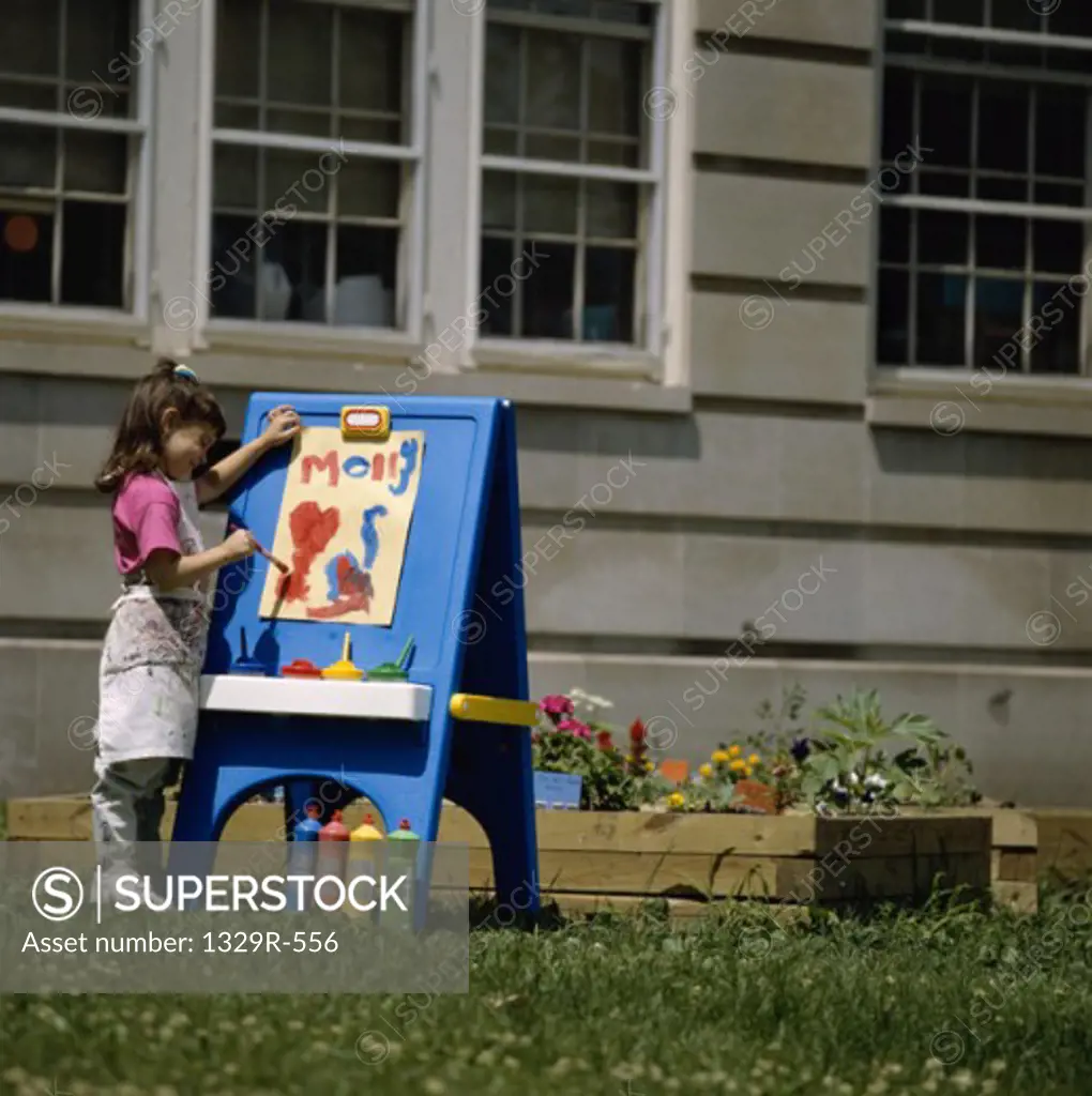 Girl painting outdoors on an easel