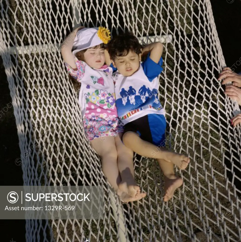 Two children sleeping in a hammock