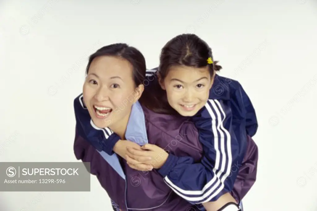 Portrait of a girl riding piggyback on a teenage girl