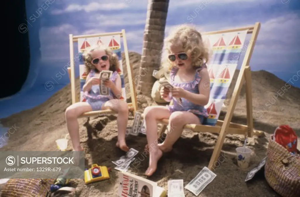 Female twins sitting on chairs counting money