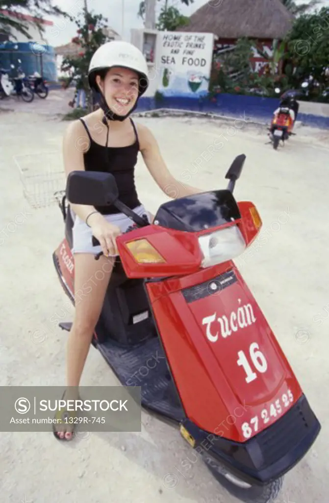 Portrait of a teenage girl sitting on a scooter