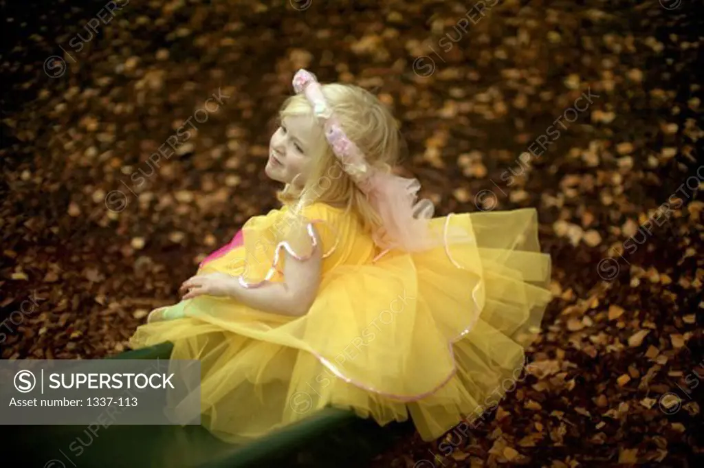High angle view of a girl dressed in a fairy costume playing in a playground