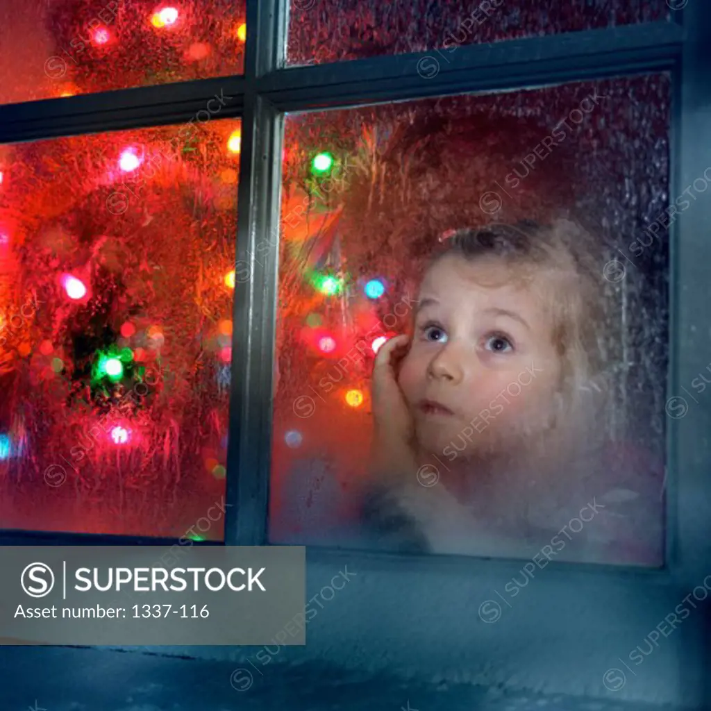 Close-up of a girl looking through a window