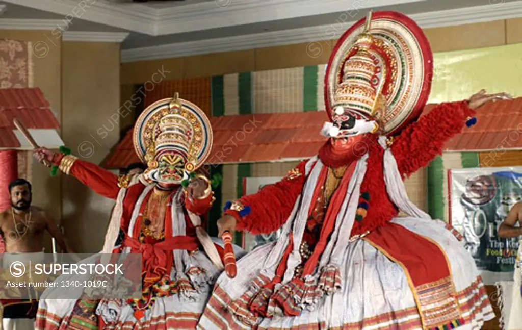 Two Kathakali dancers performing on a stage, Kerala, India