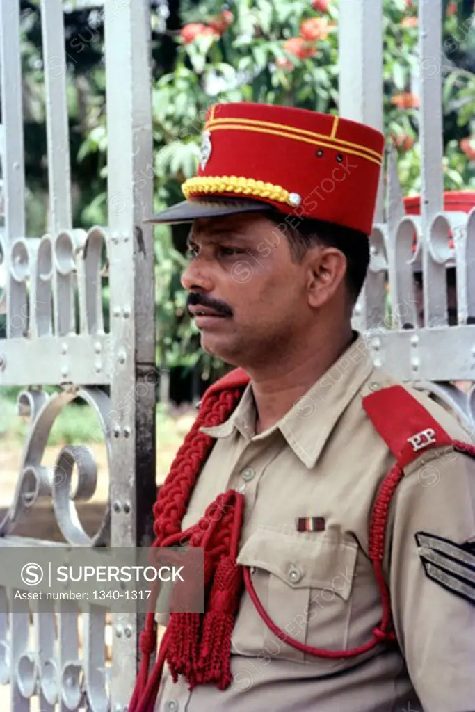 Policeman standing in front of a gate, Pondicherry, India