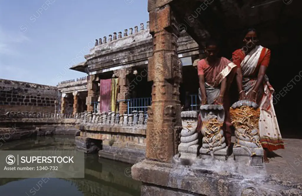 Two women worshipping in a temple, Naganathaswamy Temple, Peraiyur, Madurai District, Tamil Nadu, India