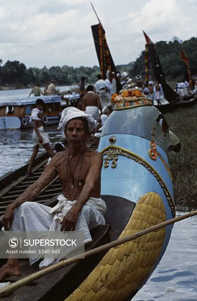 Mature man sitting on a Thiruvonam Thoni a special boat built two centuries ago for temple use, Aranmula Boat Race, Aranmula, Kerala, India
