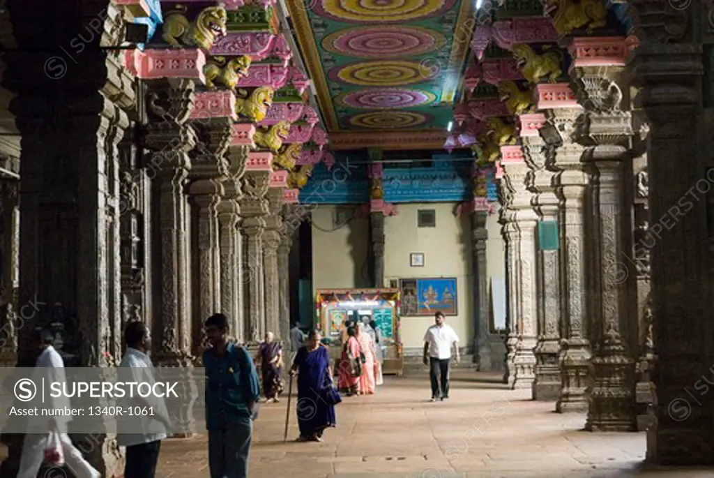 Tourists walking in a corridor of a temple, Meenakshi Amman Temple, Madurai, Tamil Nadu, India