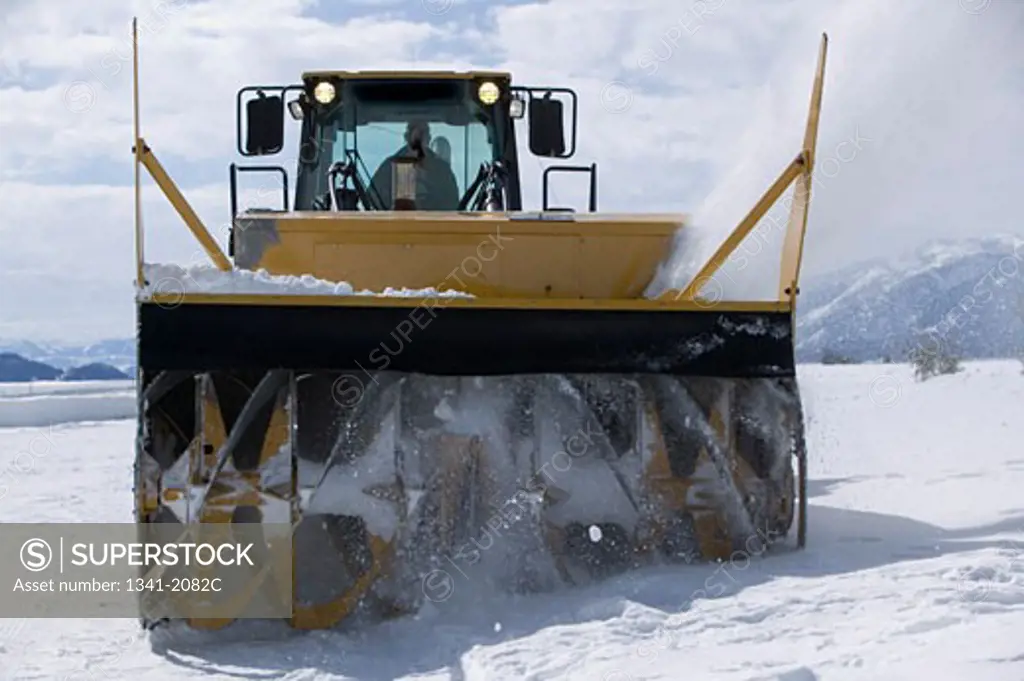 Person using a snowblower in a snow covered field