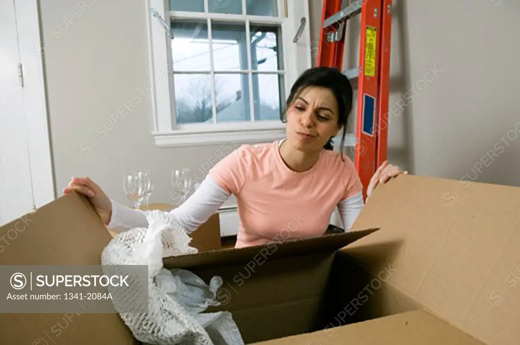 Young woman opening a cardboard box