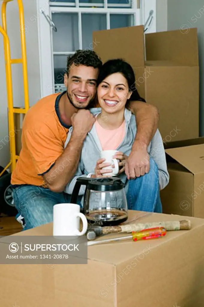 Young couple surrounded by cardboard boxes