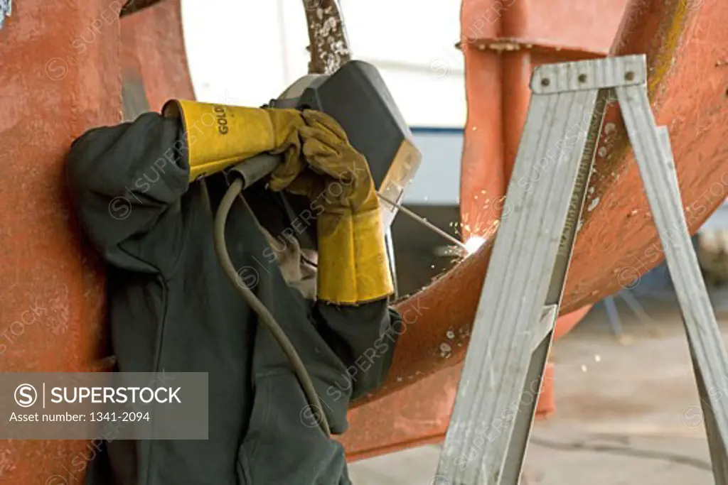 Welder welding in a shipyard