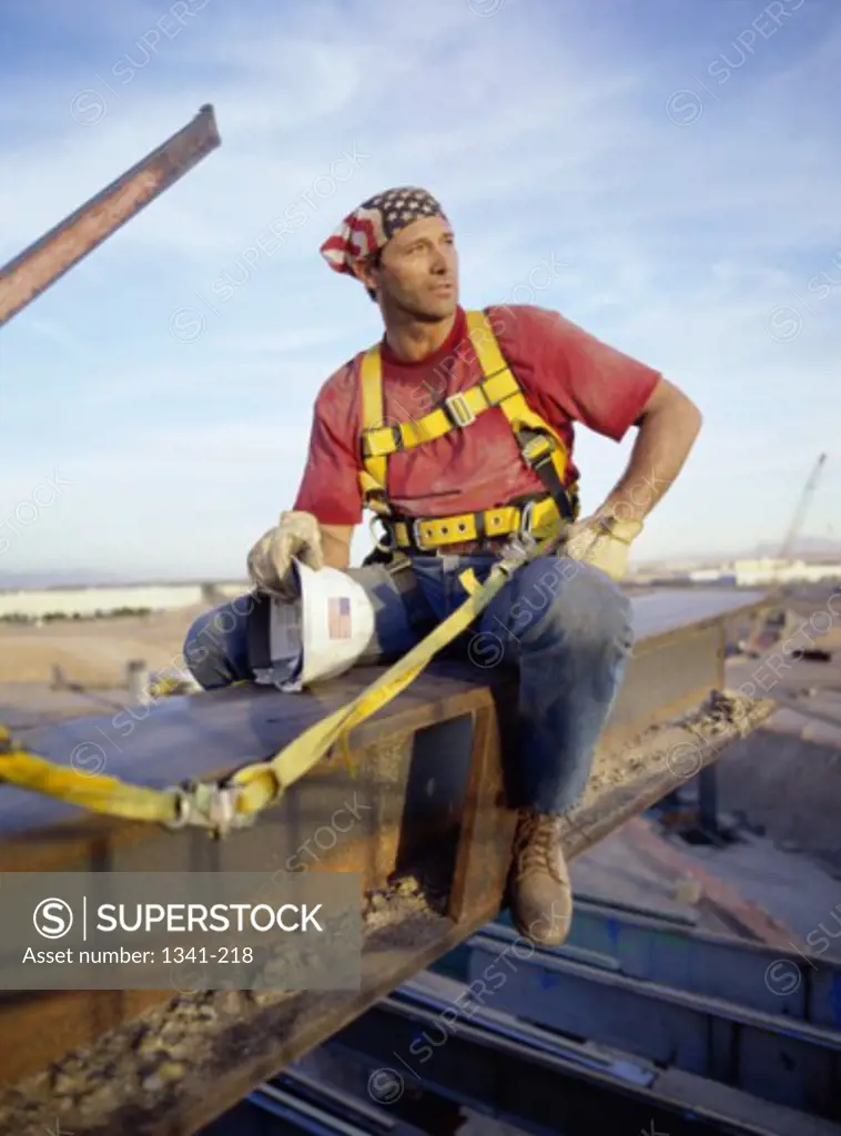Construction worker sitting on a metal beam