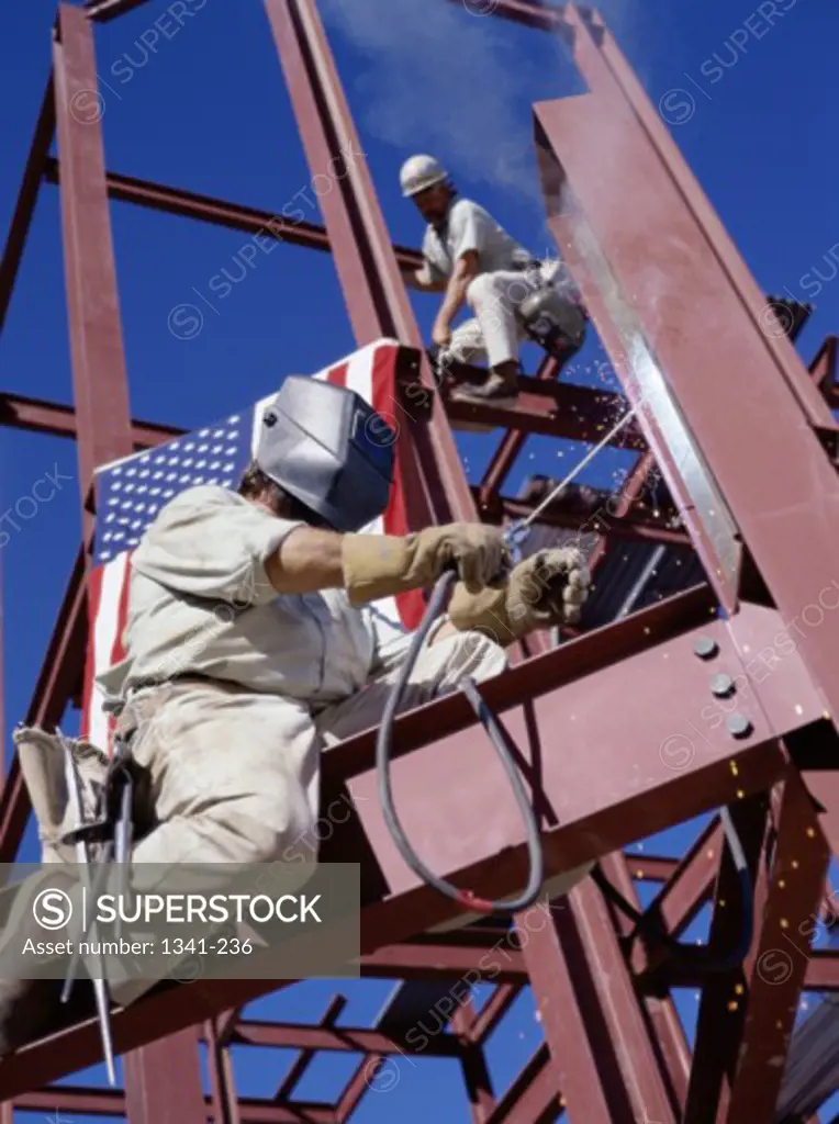 Workers working on a metal frame of a building