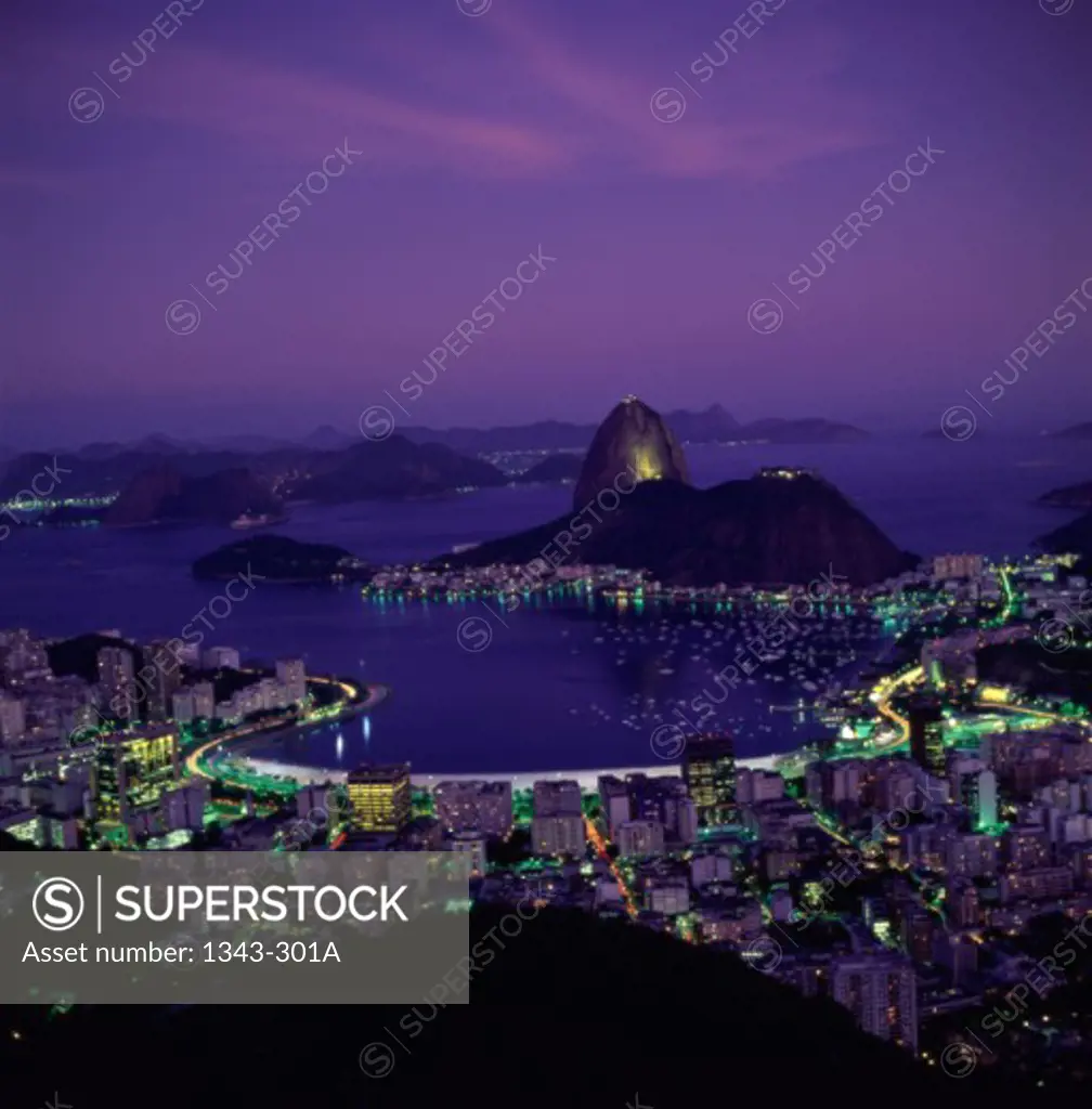Aerial view of buildings in a city lit up at night with mountains in the background, Sugarloaf Mountain, Rio de Janeiro, Brazil