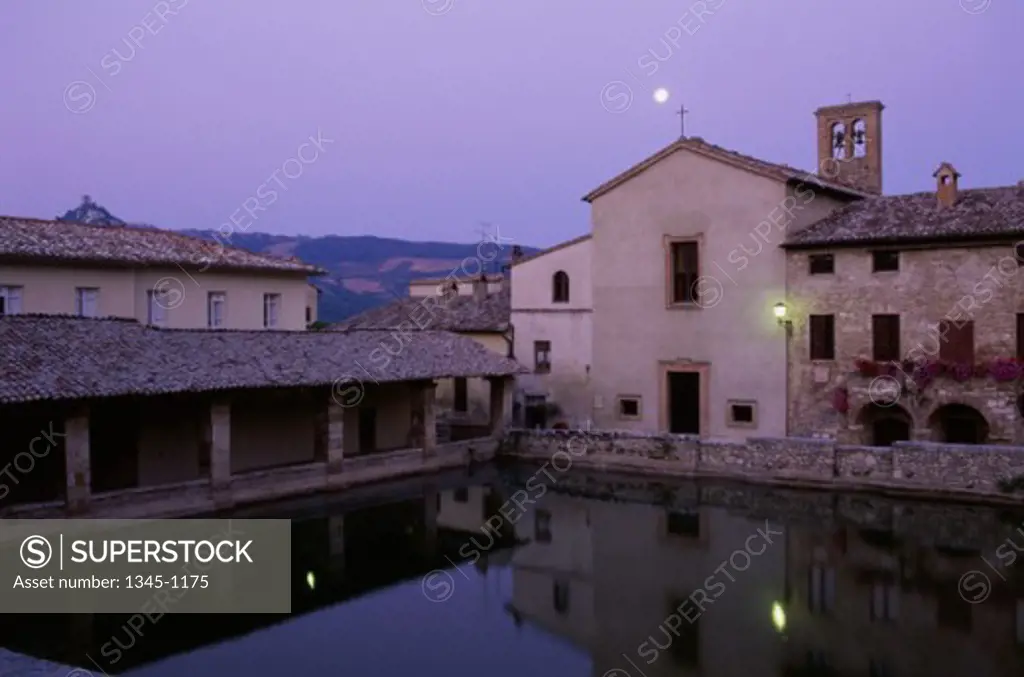Reflection of buildings in water, Roman Baths, Bagno Vignoni, Tuscany, Italy