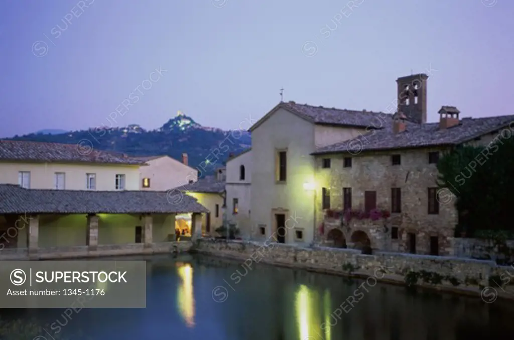 Reflection of buildings in water, Roman Baths, Bagno Vignoni, Tuscany, Italy