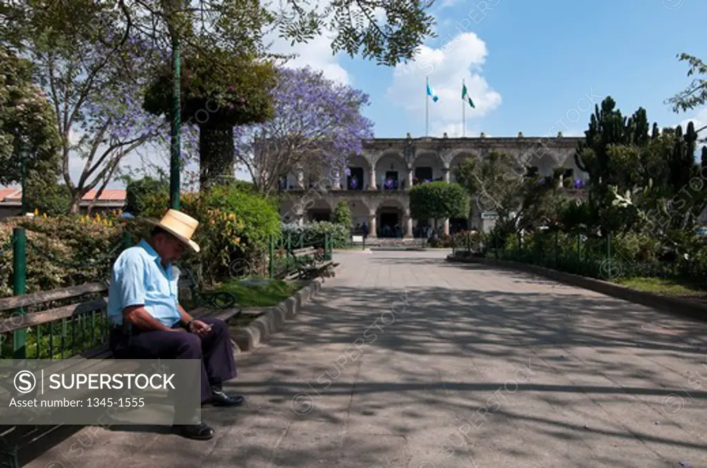 Man sitting in a park, Parque Central, Antigua, Guatemala