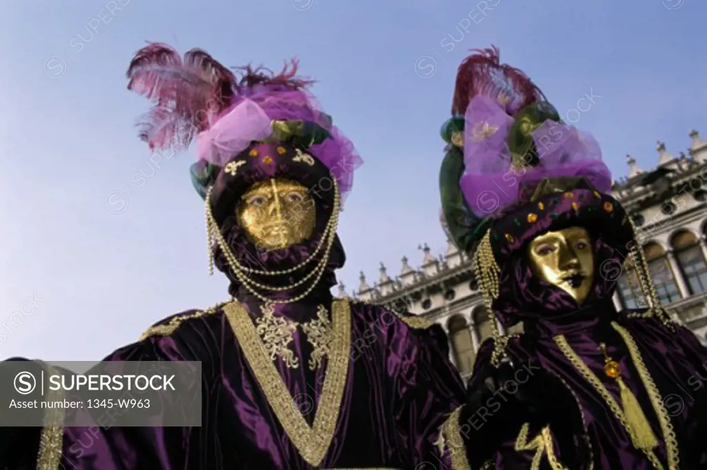 Close-up of two people wearing masquerade masks, Venice, Italy