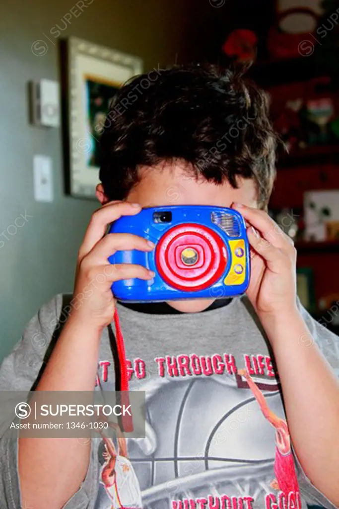 Boy taking a picture with a toy camera