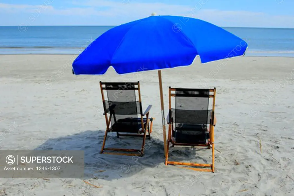 Beach umbrella and two deck chairs on the beach, Hilton Head Beach, South Carolina, USA