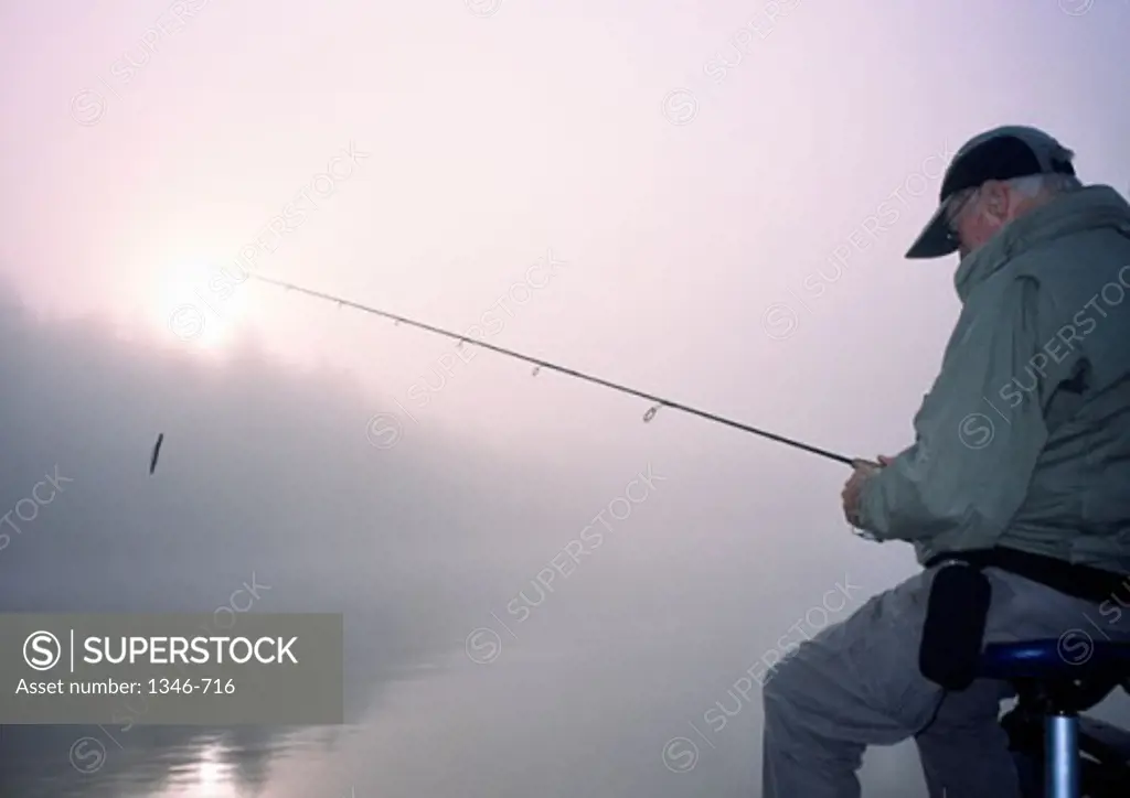 Side profile of a mature man fishing in a lake